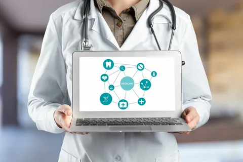 Doctor holding laptop displaying